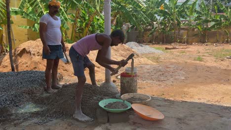 Mano-De-Obra-India-Mezclando-Cemento-Y-Agua-Manualmente-En-El-Suelo-Usando-Una-Pala