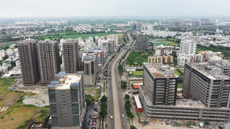 Vista-Cinematográfica-Aérea-De-La-Carretera-De-Circunvalación-Que-Pasa-Por-La-Ciudad-De-Rajkot,-Cámara-Aérea-De-Drones-Que-Muestra-Toda-La-Ciudad-De-Rajkot