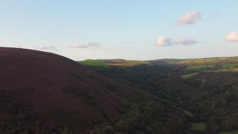 Imposing-Moorland-Over-Valley-and-Fields-at-Sunset---Aerial-Drone-Shot