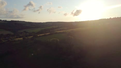 Blick-Auf-Den-Sonnenuntergang-über-Feldern-Und-Bäumen-Auf-Dem-Land-Mit-Sonneneinstrahlung