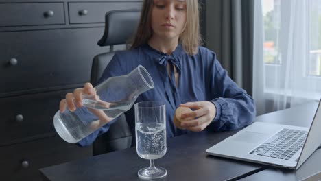 Geschäftsfrau-Gießt-Wasser-In-Glas,-Während-Sie-An-Ihrem-Schreibtisch-Arbeitet