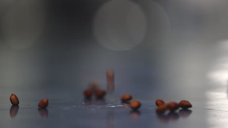 Selective-focus,-slow-motion-scene-of-peanuts,-from-which-peanut-butter-is-made,-falling-to-the-ground-from-above