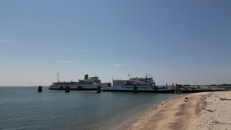 A-low-altitude-aerial-view-of-an-Orient-Point-ferry-leaving-the-terminal-out-on-Long-Island,-NY-on-a-sunny-day