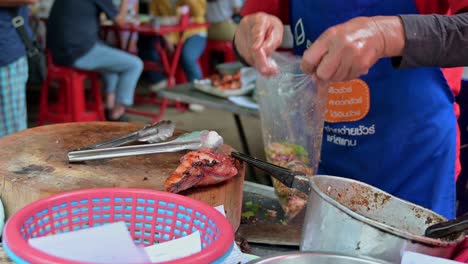 Traditional-Northeastern-Thai-food-called-Laab-with-grilled-pork,-prepared-by-a-local-cook-in-a-roadside-restaurant-in-the-streets-of-Bangkok,-Thailand