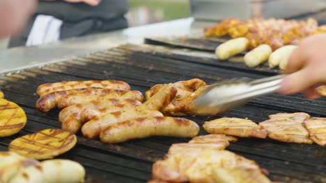 Close-Up-Of-People-Grilling-Sausages,-Chicken-And-Patty-With-Food-Tongs