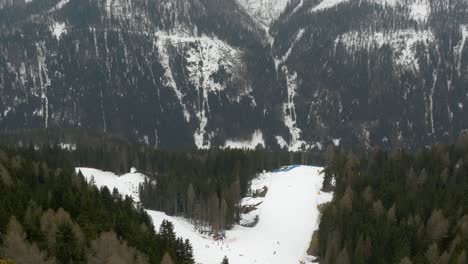 Telephoto-shot-of-Dolomite-alps-with-people-skiing-on-slope,-static,-day