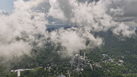 Highlands-North-Carolina-Aerial-v13-high-altitude-drone-fly-through-misty-clouds-reveals-town-center-surrounded-by-lush-green-forests-in-mountainous-landscape---Shot-with-Mavic-3-Cine---July-2022