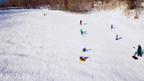 4K-Drohnenvideo-Von-Menschen,-Die-An-Einem-Verschneiten-Wintertag-An-Der-University-Of-Alaska-Fairbanks-Schlitten-Fahren