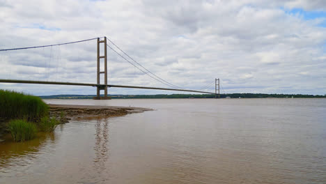 Captivating-aerial-drone-view-of-Humber-Bridge,-the-12th-largest-suspension-span-globally,-crossing-the-River-Humber,-connecting-Lincolnshire-to-Humberside-amid-traffic