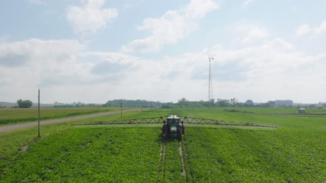 Aufsteigende-Luftaufnahme,-Die-Zeigt,-Wie-Ein-Traktor-Pestizide-Versprüht,-Und-Das-Gesamte-Landwirtschaftliche-Feld
