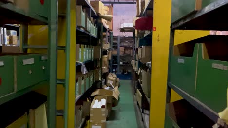 Camera-moves-between-shelves-with-box-with-stuff-in-logistic-warehouse