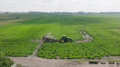 Luftaufnahme-Eines-Traktors-Mit-Auslegersprühaufsatz,-Der-Pestizide-Auf-Dem-Feld-Versprüht
