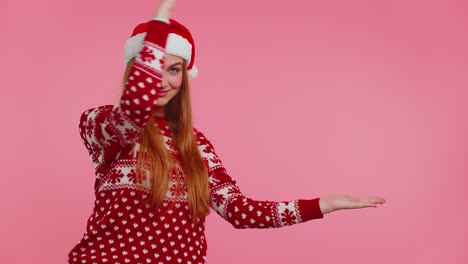 Woman-wears-red-New-Year-sweater-deer-showing-thumbs-up-and-pointing-at-on-blank-advertisement-space