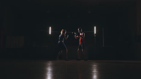 fitness-woman-athlete-boxing-punching-focus-mitts-enjoying-intense-exercise-female-fighter-training-friend-in-gym-workout-together-slow-motion