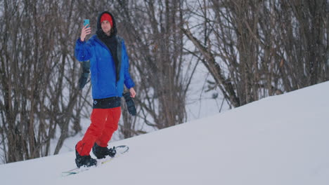 Usa-Tu-Teléfono-Inteligente-Para-Tomar-Fotografías-De-Paisajes-Mientras-Haces-Snowboard-En-La-Pista-De-Esquí