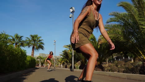 In-the-leisure-of-slow-motion,-a-young-woman-glides-on-a-longboard-near-palm-trees,-her-summer-outfit-of-shorts-and-sneakers-enhancing-the-scene