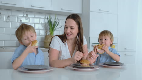 Mamá-Con-Dos-Hijos-Pequeños-Está-Comiendo-Hamburguesas-En-Casa.