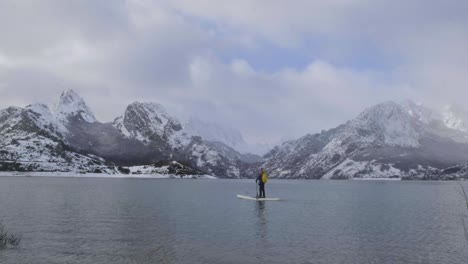 Hombre-En-Paddle-Board-Entre-El-Agua-Y-Las-Montañas-En-La-Costa
