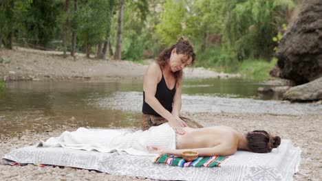 Woman-doing-massage-on-lake-shore