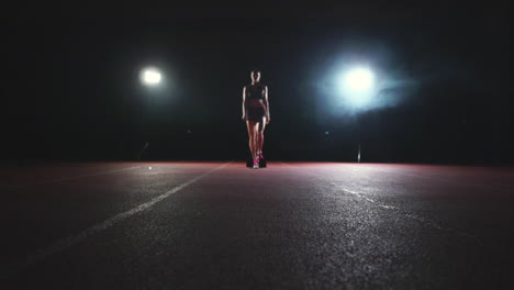 Female-athlete-on-a-dark-background-to-run-the-sprint-of-the-cross-country-pad-on-the-treadmill-on-a-dark-background