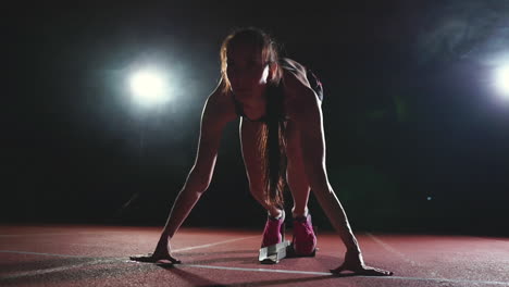 Professionelle-Sportlerin-Auf-Dunklem-Hintergrund,-Um-Den-Sprint-Mit-Joggingschuhen-In-Turnschuhen-Auf-Der-Strecke-Des-Stadions-Auf-Dunklem-Hintergrund-Zu-Laufen