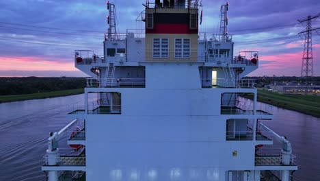 Aerial-reveal-of-the-Stern-of-the-container-ship-the-Vega-Daytona-sailing-at-sunset