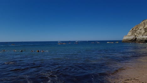 People-enjoying-the-ocean-water-and-Summer-sun-at-Benagil-Beach,-Portugal