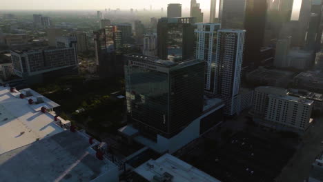 Aerial-view-over-the-Marriott-hotel,-toward-luxury-high-rise-in-downtown-Houston,-golden-hour-in-Texas,-USA