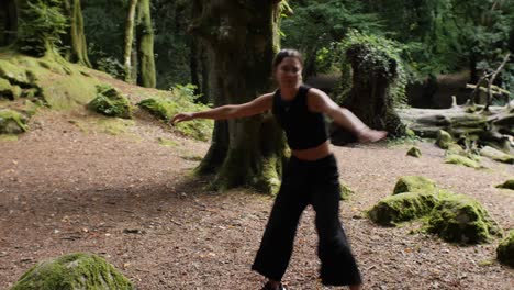 Fit-dancer-performing-ginga-in-lush-forest-scene