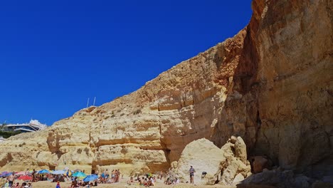 People-enjoying-a-day-at-Benagil-Beach-on-the-Southern-Coast-of-the-Algarve,-Portugal