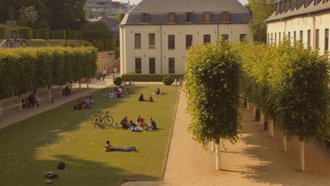 People-Relaxing-On-The-Green-Lawn-In-La-Cambre-Abbey,-Brussels,-Belgium---wide