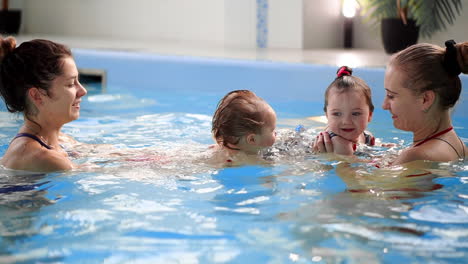 Gruppe-Von-Müttern-Mit-Ihren-Kleinen-Kindern-Beim-Kleinkindschwimmkurs