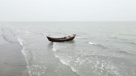 Empty-Wooden-Fishing-Boat-On-Kuakata-Sea-Beach-With-Waves-Gently-Breaking-Underneath