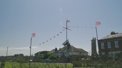 Wide-shot-of-three-coronation-flags-swaying-in-front-of-Harwich-houses