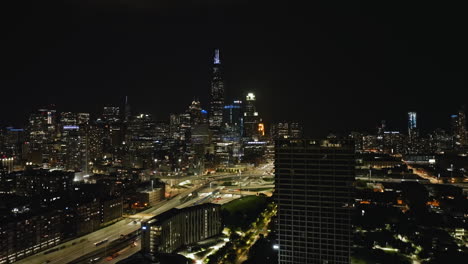 Aerial-view-of-the-night-lit-Jane-Byrne-Interchange-and-the-towering-Chicago-skyline