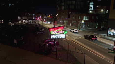Aerial-rising-tilt-shot-in-front-of-the-Erie-Lasalle-Body-Shop-sign,-night-in-Chicago,-USA