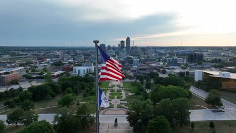 American-flag-and-Iowa-state-flag-waving-in-front-of-capital-city,-Des-Moines,-IA