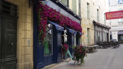 Slow-orbiting-shot-of-a-shopfront-with-beautiful-flower-decorations-in-Nimes