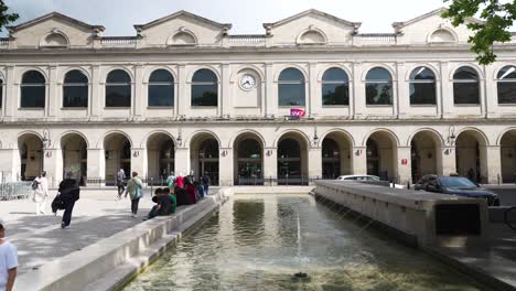 Carro-Lento-Hacia-Los-Viajeros-Que-Se-Dirigen-A-La-Estación-De-Tren-De-Nimes-Con-Una-Fuente-De-Agua