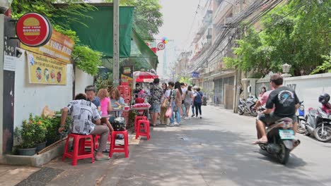 Local-diners-and-tourists-lining-up-for-the-famous-Somtam-Thai-papaya-salad-and-some-Isan-Northeastern-Thai-food-in-the-streets-of-Bangkok,-Thailand