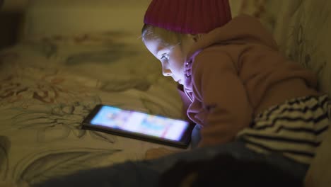 A-young-girl-immersed-in-cartoons-on-the-tablet