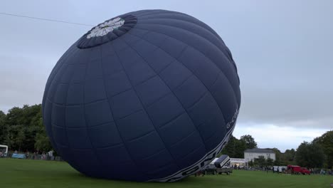 Hand-held-shot-of-a-hot-air-balloon-filling-up-with-air-at-Strathaven-Balloon-Festival