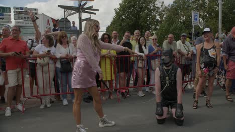 Woman-posing-with-a-man-on-his-knees-wearing-a-dog-mask-and-a-leash-during-the-Antwerp-Pride-Parade-2023-in-Belgium