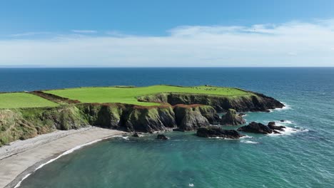 Coast-Of-Ireland-aerial-to-Dunabrattin-Head-passing-a-golden-beach-at-The-Copper-Coast-Waterford-on-a-summer-day