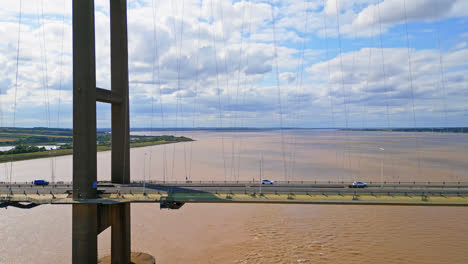 Aerial-drone-reveals-Humber-Bridge,-12th-largest-suspension-span,-spanning-River-Humber,-connecting-Lincolnshire-to-Humberside-with-constant-traffic
