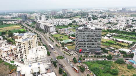 Escena-De-La-Carretera-De-Circunvalación-Que-Pasa-Por-La-Ciudad-De-Rajkot-Rodeada-De-Edificios-Altos,-Edificios-Bajos-Visibles-En-El-Fondo,-Vista-Aérea-Del-Edificio-Rascacielos-En-La-Ciudad-De-Rajkot