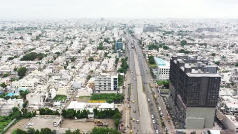 Filmische-Luftaufnahme-Der-Ringstraße-Der-Stadt-Rajkot,-Luftdrohnenkamera-Bewegt-Sich-Vorwärts-Und-Zeigt-Viele-Wohnhäuser-Auf-Beiden-Seiten-Der-Straße