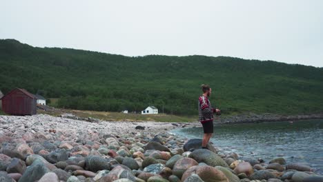 Mann-Fischt-In-Einem-Fluss-Mit-Felsen-Und-Einem-Grünen-Berg-Im-Hintergrund