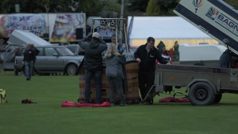 Hand-held-shot-of-crews-setting-up-their-basket-at-the-Strathaven-Balloon-Festival