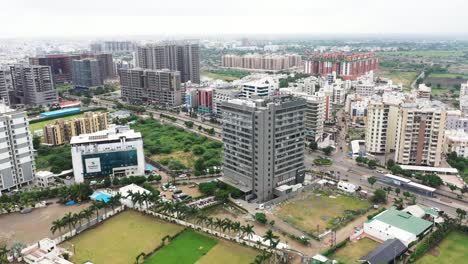 Vista-Aérea-De-La-Ciudad-De-Rajkot,-La-Cámara-De-Drones-Se-Mueve-Y-Los-Edificios-Comerciales-Y-Residenciales-De-Gran-Altura-Son-Visibles-En-Todos-Los-Lados-De-La-Ciudad